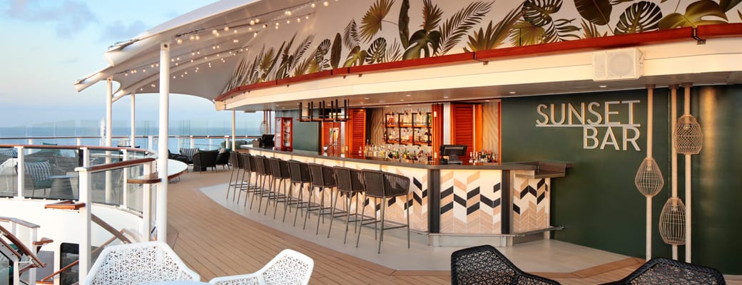 Sunset Bar p&aring; Celebrity cruise skibets &oslash;verste d&aelig;k med tropisk palmeblade-dekoration, udend&oslash;rs barstemning og havudsigt