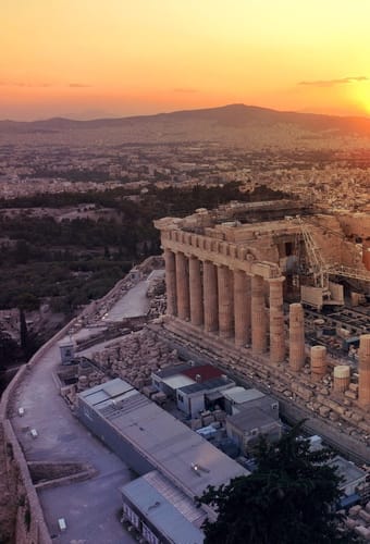 Akropolis og Parthenon i Athen set fra luften i solnedgang med storbyen bredt ud omkring