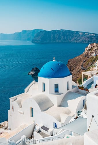 Oia på Santorini med hvide huse og blå kupler højt over calderaen i Det Ægæiske Hav